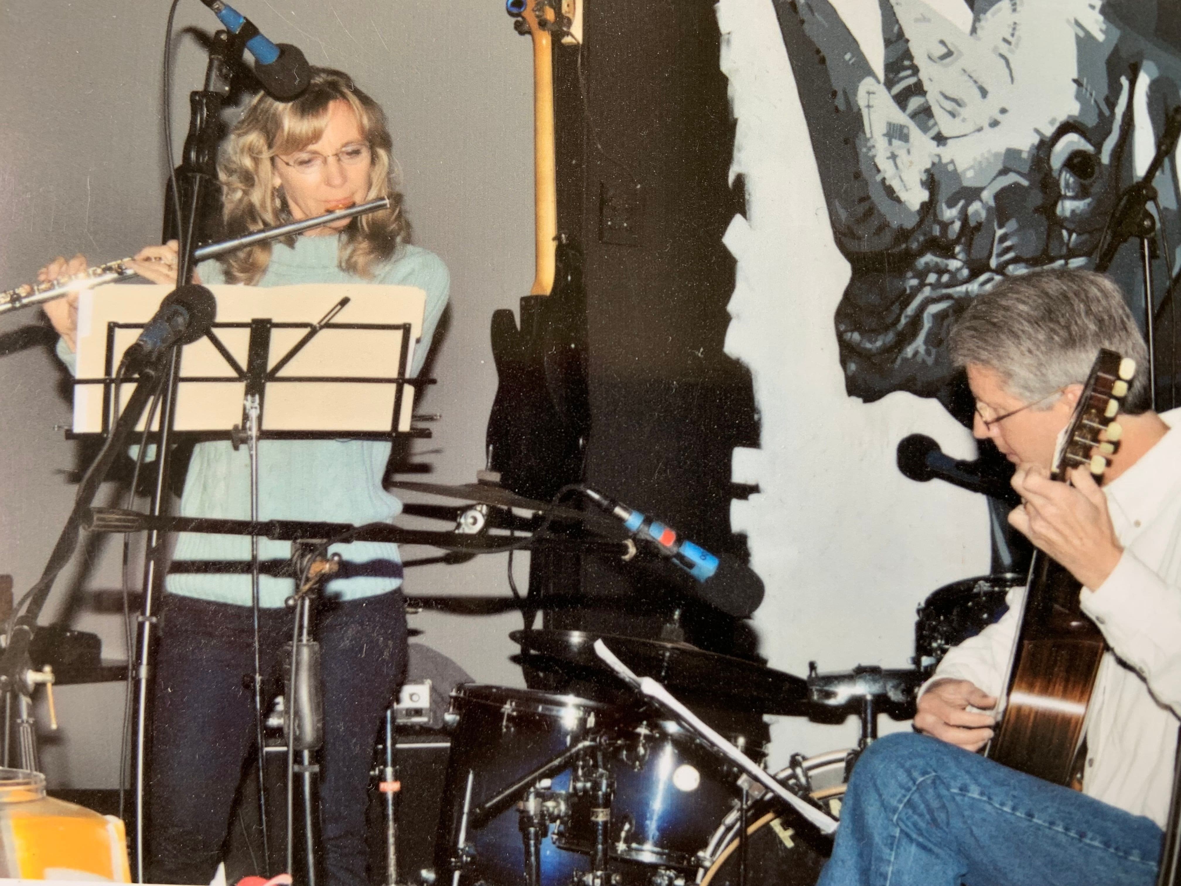 Chuck and Laura Rogers playing the guitar and flute together.